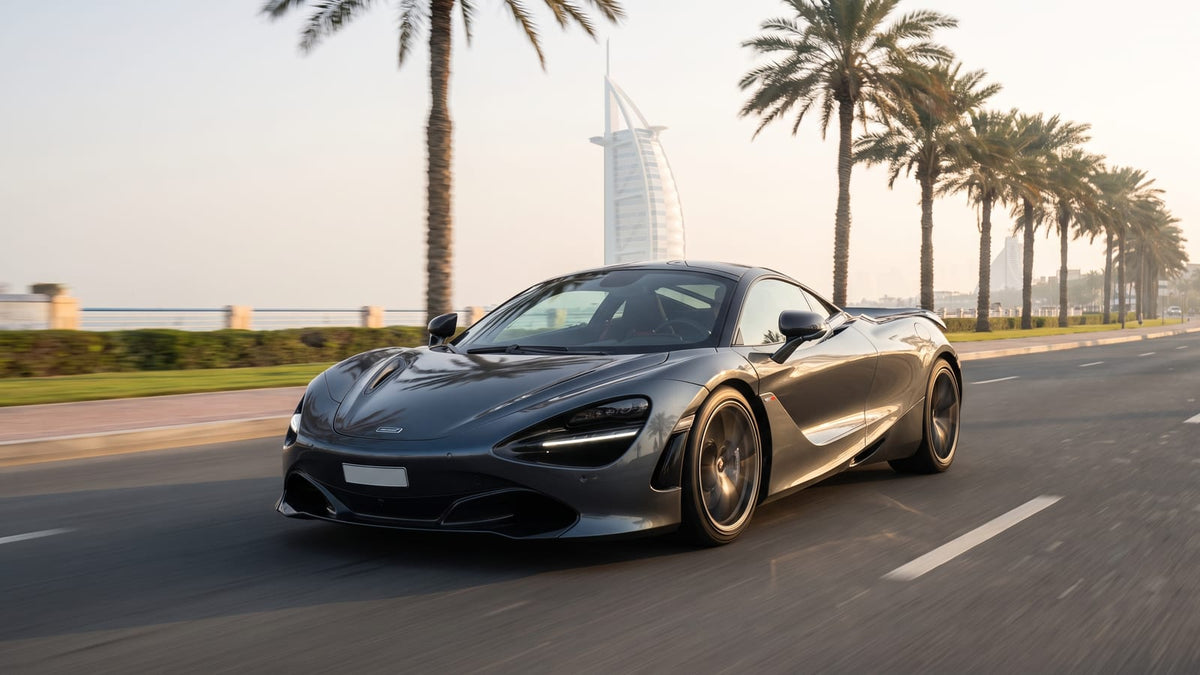 Supercar driving along Jumeirah Beach Road in Dubai winter sunshine